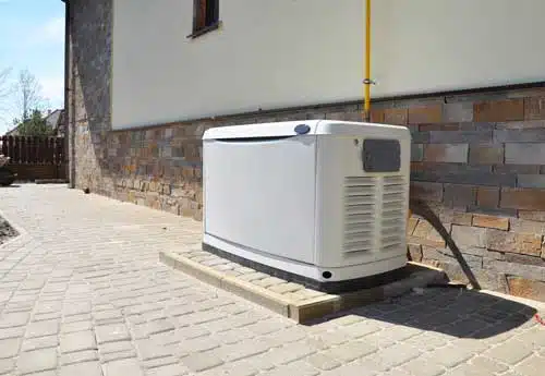 White generator on tan paver patio.